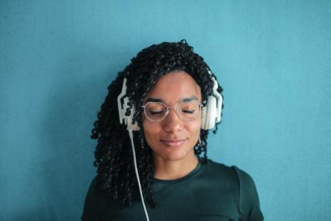 Photo of a woman listening to a pair of headphones