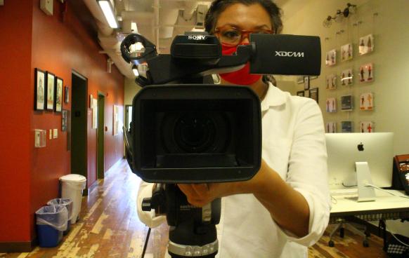 A woman looks through the Sony Z150 Video Camera 