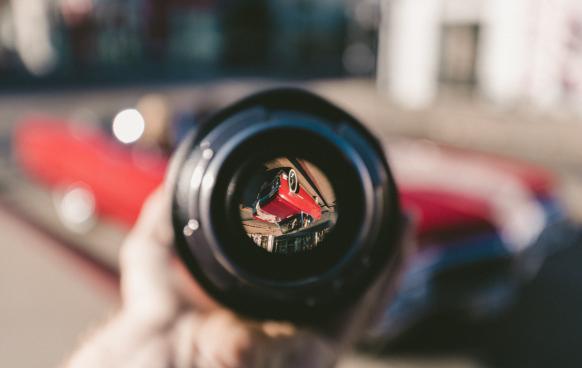 Photo of a lens pointed at a car. Everything is out of focus but the car seen through the lens upside down. Photo by Jakob Owens on Unsplash