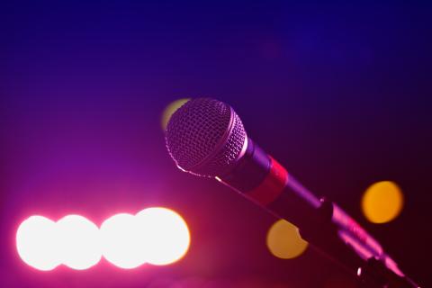 Photo of a microphone on stage backlit